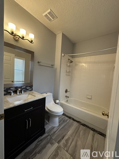 A bathroom with a toilet, sink, and bathtub.