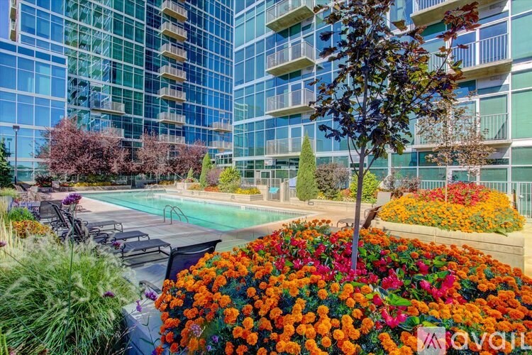 A beautiful outdoor scene with a pool, chairs, and a tree.