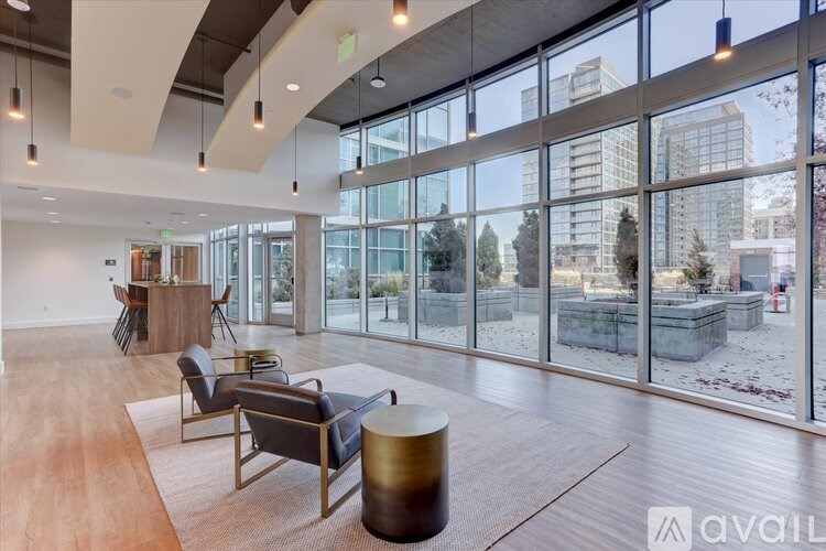A spacious room with wooden floors and large windows overlooking a construction site.