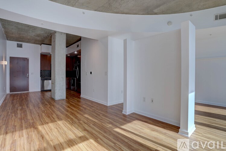 A spacious room with wooden floors and white walls.