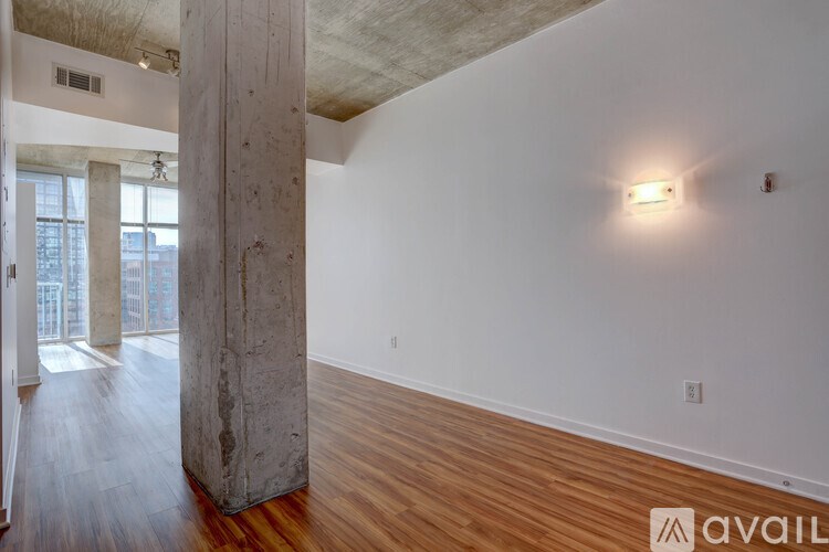 A room with a wooden floor and a large pillar.