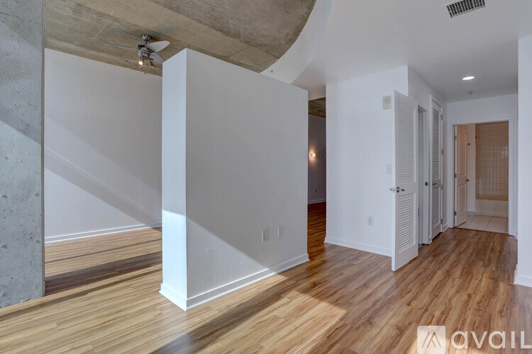 A spacious room with wooden floors and white walls.