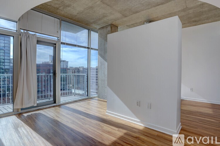 A room with a large window and a wooden floor.