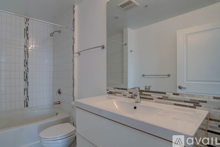 A white bathroom with a toilet, sink, and bathtub.
