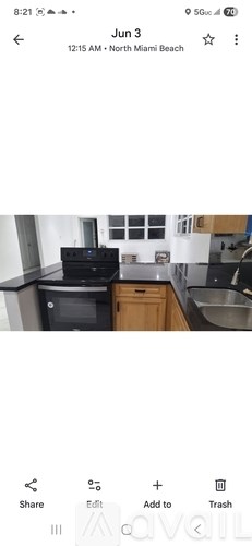 A kitchen with wooden cabinets and a black countertop.