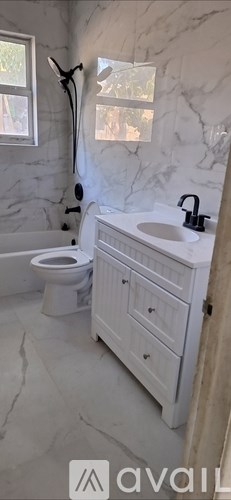 A bathroom with a marble wall and a white toilet.