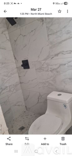 A white toilet in a bathroom with marble walls.
