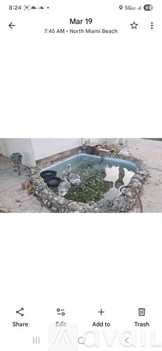 A small pool surrounded by rocks and plants.