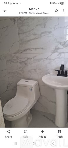 A white toilet and sink in a bathroom.