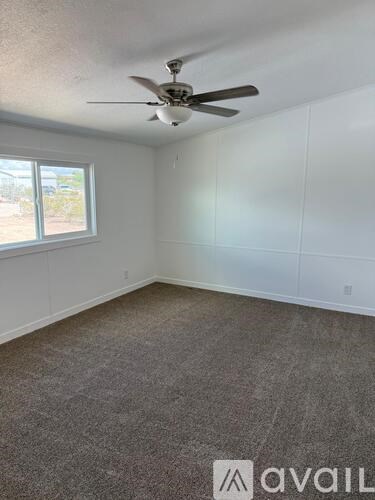 A room with a ceiling fan and a window.