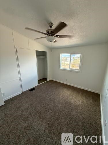 A room with a ceiling fan and a window.