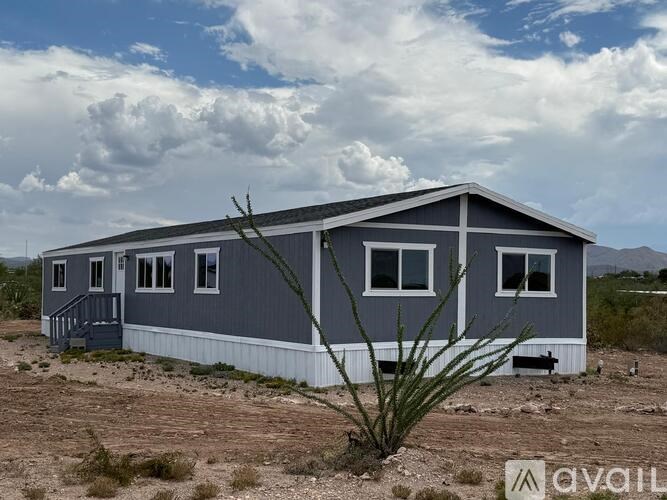 A blue and white house with a sign that says "available" in front of it.