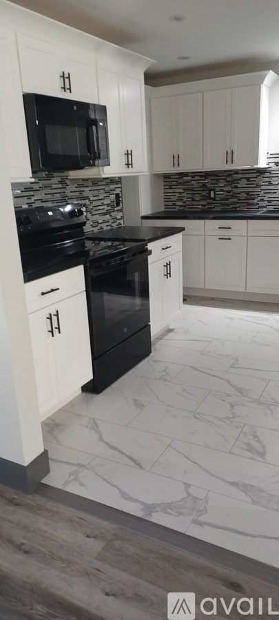 A kitchen with black countertops and white cabinets.