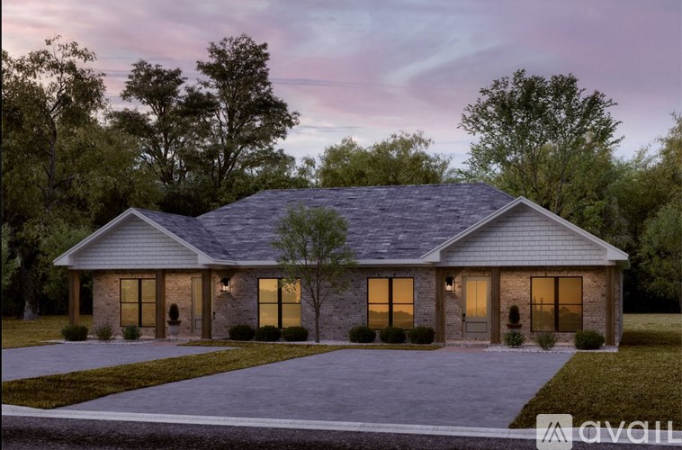 A house with a grey roof and a driveway in front of it.