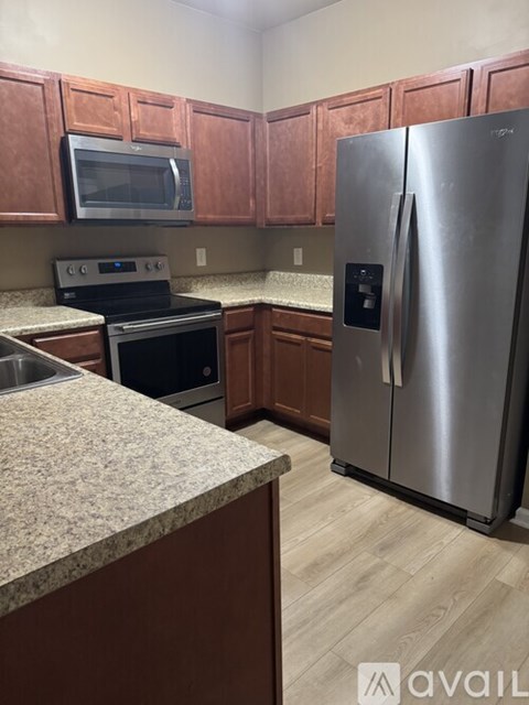 A kitchen with wooden cabinets and a granite countertop.