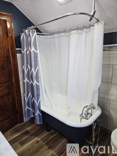 A bathroom with a white tub and a shower curtain.