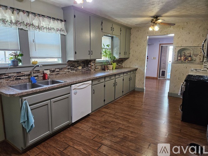 A kitchen with wooden floors and a stone counter.