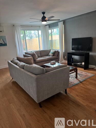 A living room with a grey couch and a television.