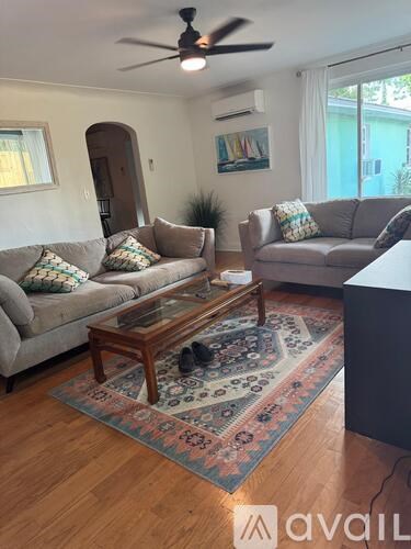 A living room with a couch, a coffee table, and a rug.