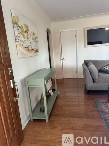 A room with a green cabinet and a grey couch.