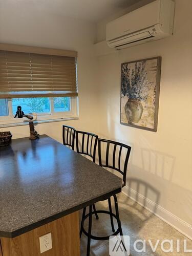 A kitchen with a granite countertop and a window with blinds.