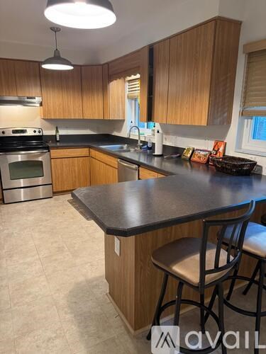 A kitchen with wooden cabinets and a black countertop.