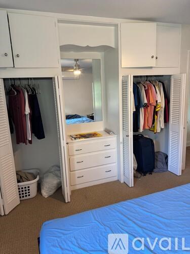 A bedroom with a bed, wardrobe, and a mirror.