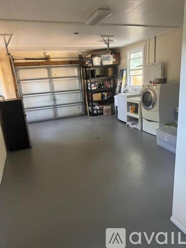 A laundry room with a washer and dryer, a black speaker, and a white cabinet.