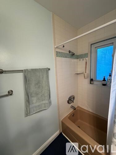 A bathroom with a towel hanging on the towel rack.