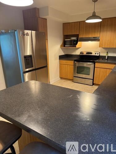 A kitchen with a granite countertop and stainless steel appliances.