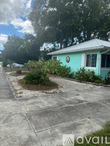 A house with a blue front yard and a white roof.