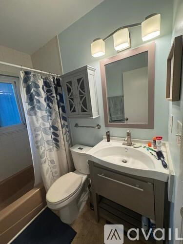 A bathroom with a toilet, sink, and mirror.