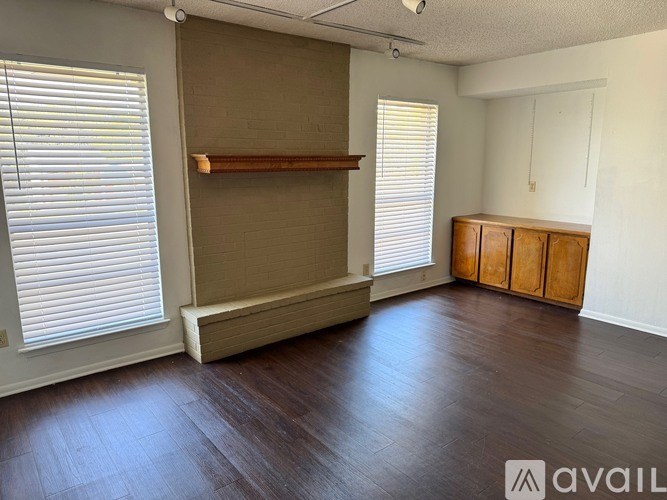 A room with a wooden floor, a shelf, and a cabinet.
