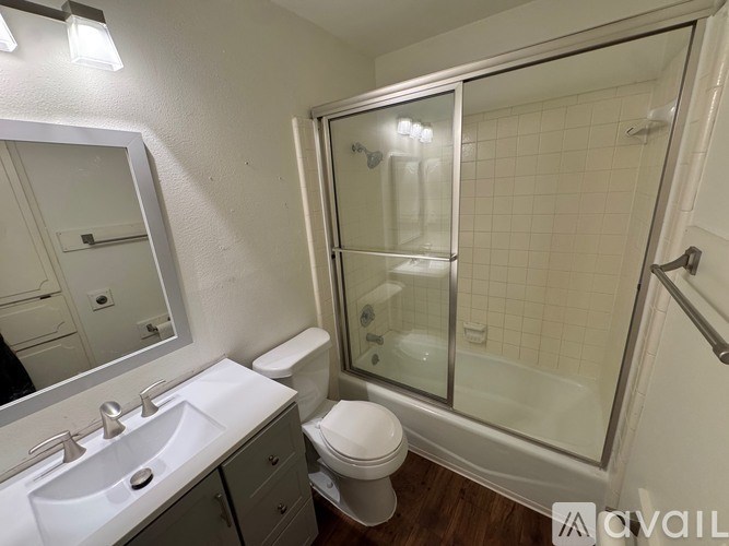A bathroom with a toilet, sink, and shower.