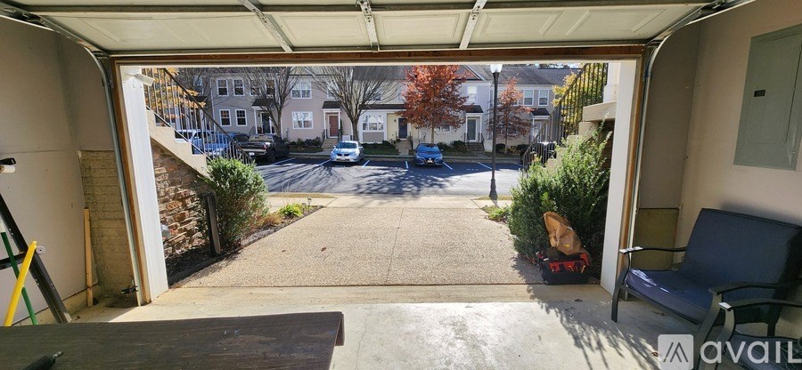 A view from a garage looking out to a street with cars and houses.