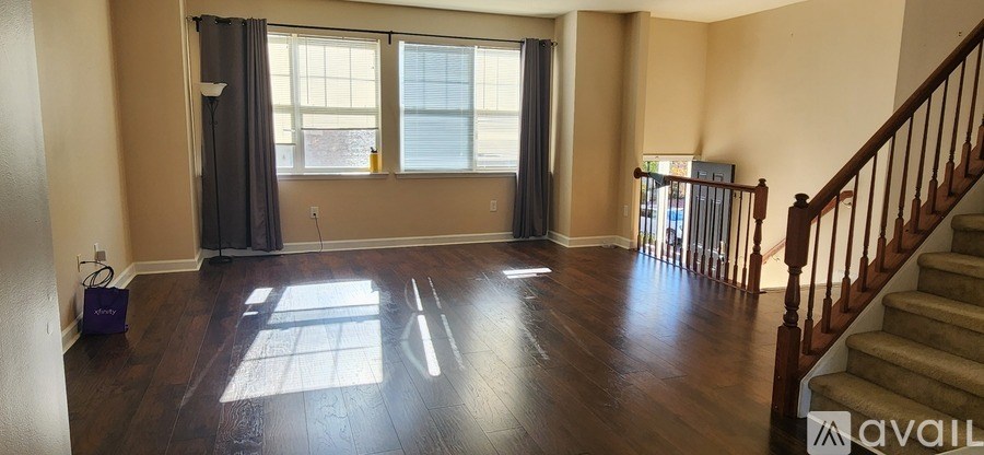 A room with wooden floors and a staircase.