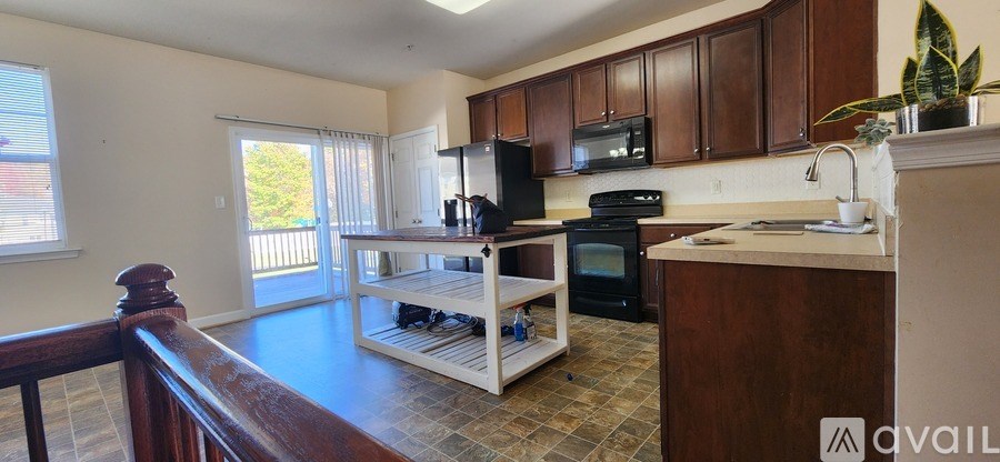 A kitchen with a black refrigerator, microwave, and oven.