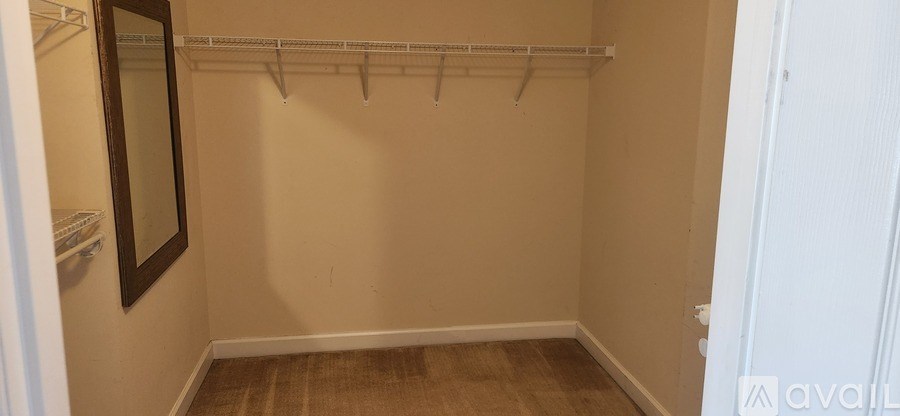 A small, empty closet with a mirror and a shelf.