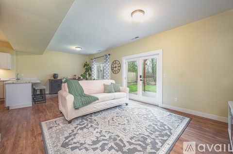 A living room with a white couch and a rug.