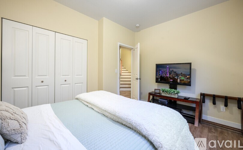 A bedroom with a bed, a dresser, and a painting on the wall.