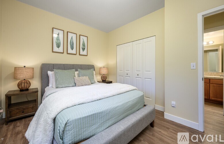 A bedroom with a bed, two lamps, and a cabinet.