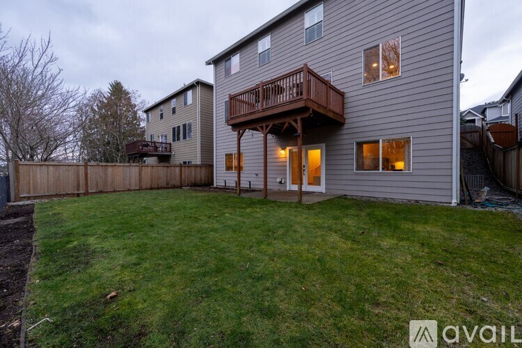 A house with a deck and a fence in front of it.