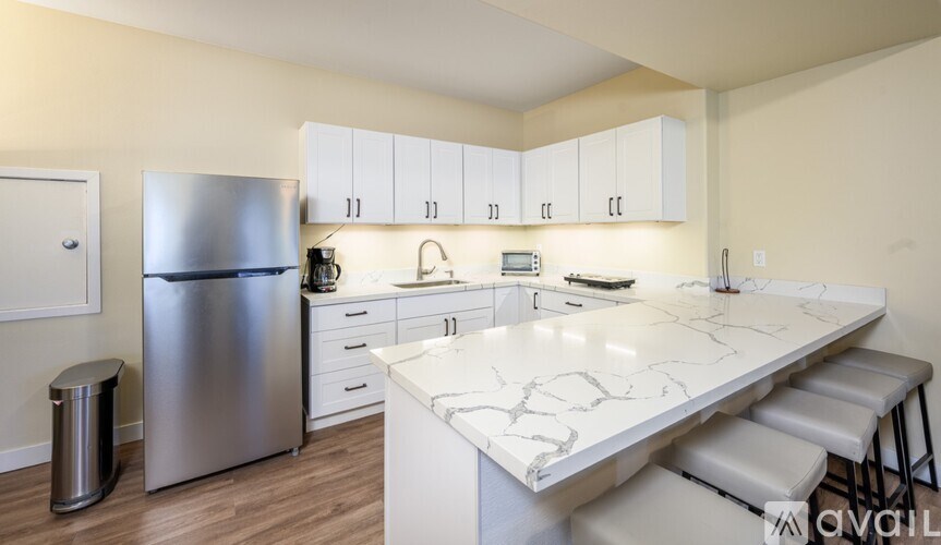 A kitchen with a marble countertop and stainless steel appliances.