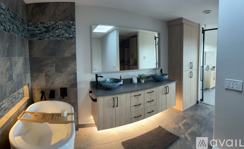 A bathroom with a toilet, sink, and mirror.