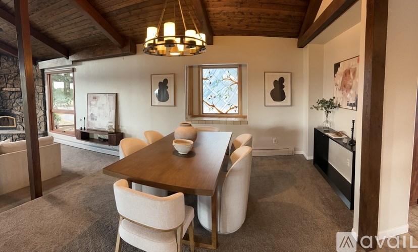 A dining room with a wooden table and chairs.