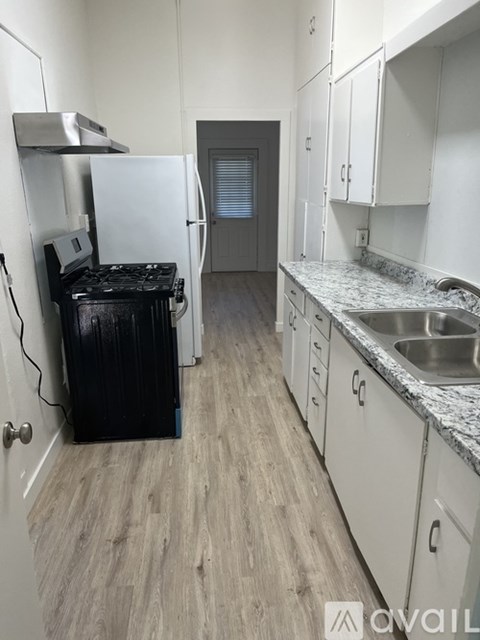 A kitchen with a black fridge and a sink.