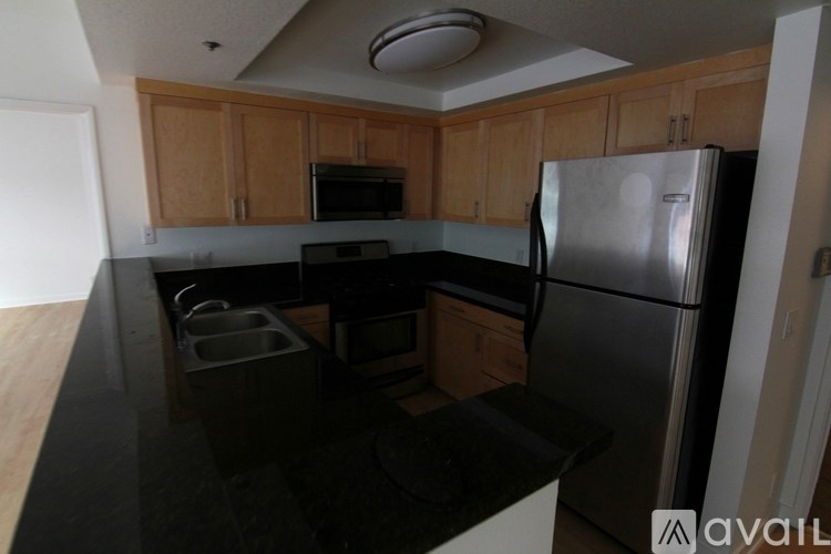 A kitchen with wooden cabinets and a black countertop.