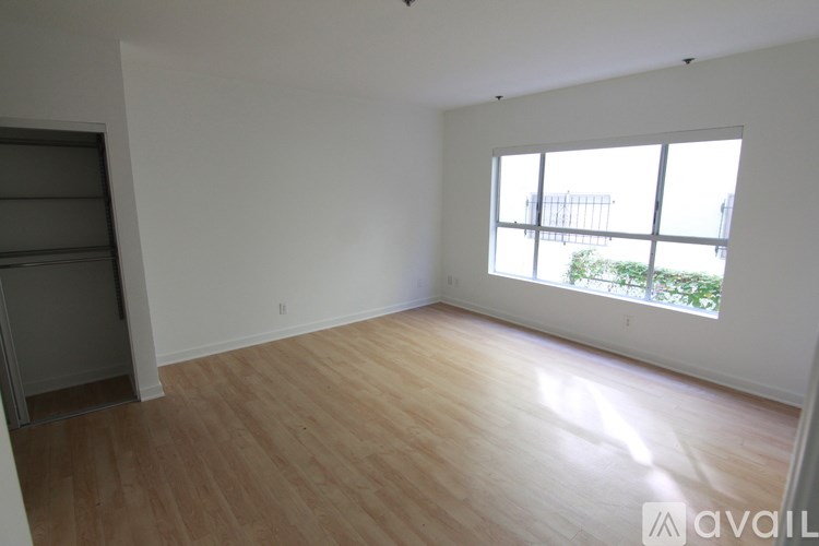 A room with wooden flooring and a large window.