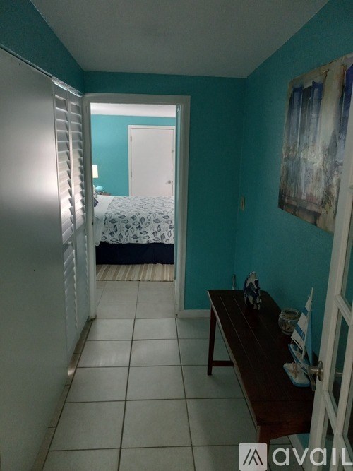 A room with a bed and a painting on the wall.