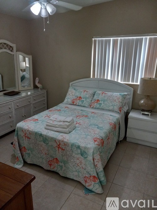 A bedroom with a bed, dresser, and mirror.